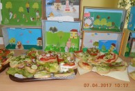 Zdjęcie przedstawia gotowe kanapki na stole, w tle rysunki 3d