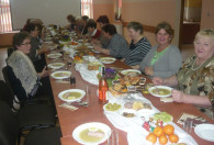 Zdjęcie przedstawia kobiety podczas uroczystego jedzienia posiłku