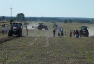 pięć traktorów oraz grupa ludzi na polu podczas pokazu